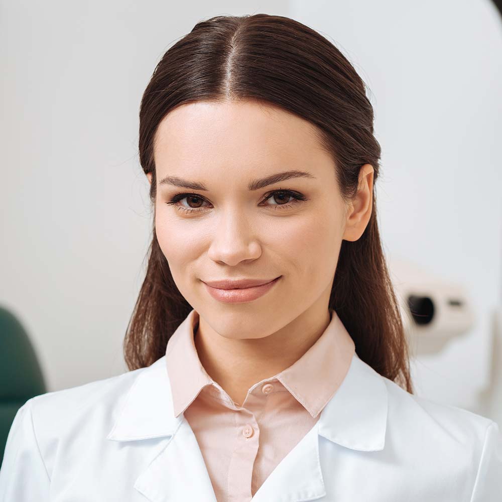 portrait of smiling optician in white coat holding ELY56CZ